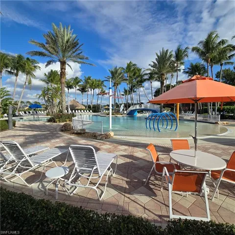 Community pool with a patio area and a water slide