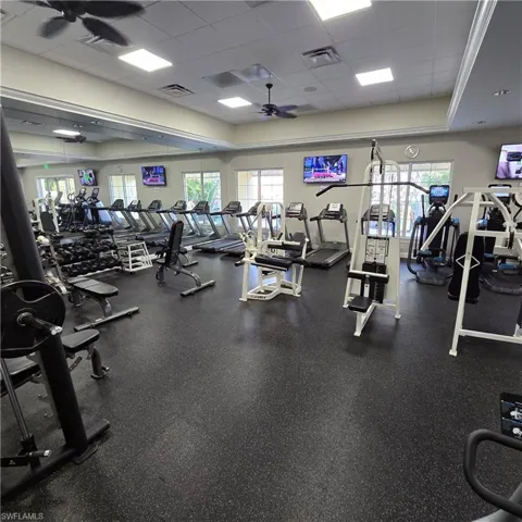 Gym featuring a ceiling fan and a drop ceiling
