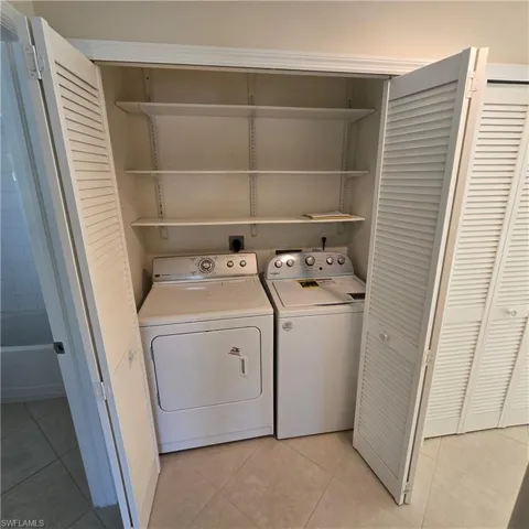 Washroom featuring light tile patterned floors and washer and dryer