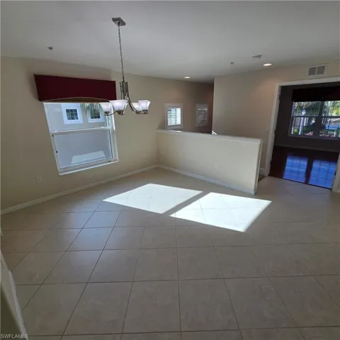 Unfurnished dining area with a chandelier, light tile patterned floors, and recessed lighting