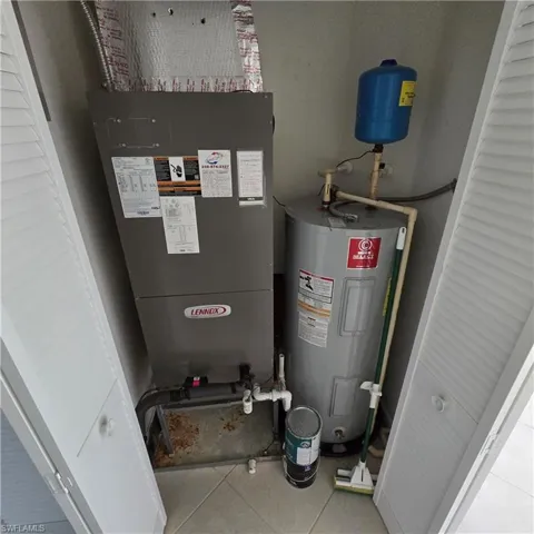 Utility room featuring water heater and heating unit