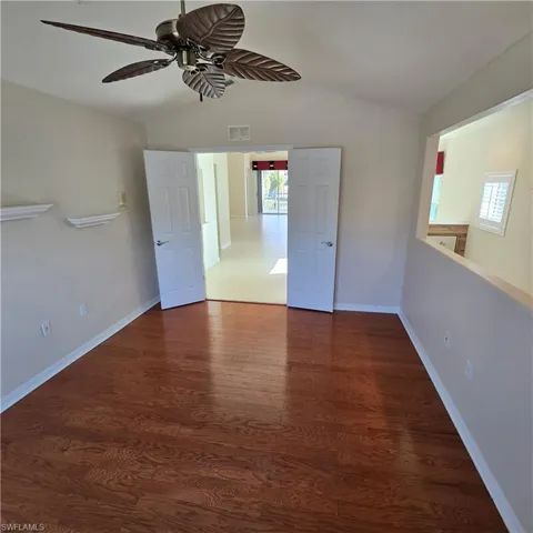 Spare room with vaulted ceiling, dark wood-style flooring, and ceiling fan