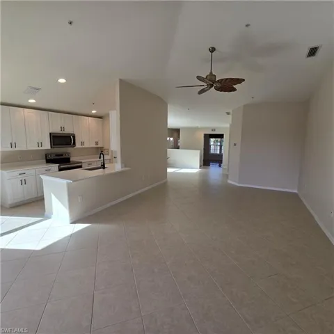 Kitchen with white cabinetry, appliances with stainless steel finishes, open floor plan, recessed lighting, and a ceiling fan