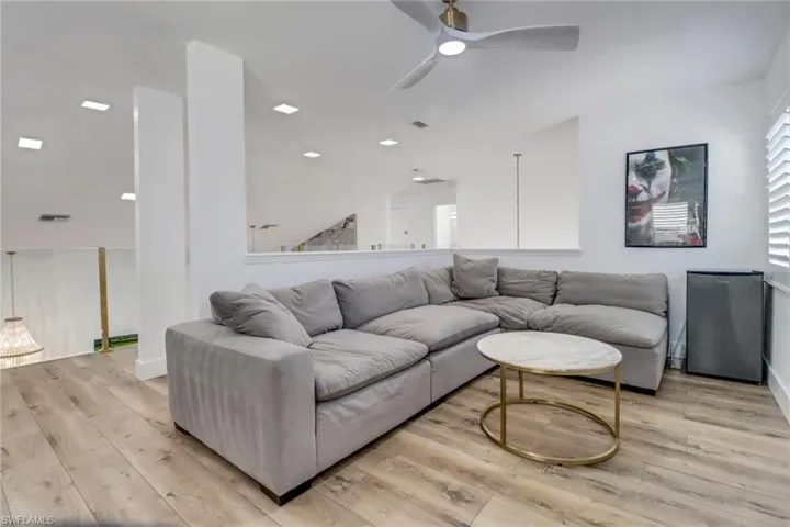 Living area featuring a ceiling fan, baseboards, visible vents, and light wood finished floors