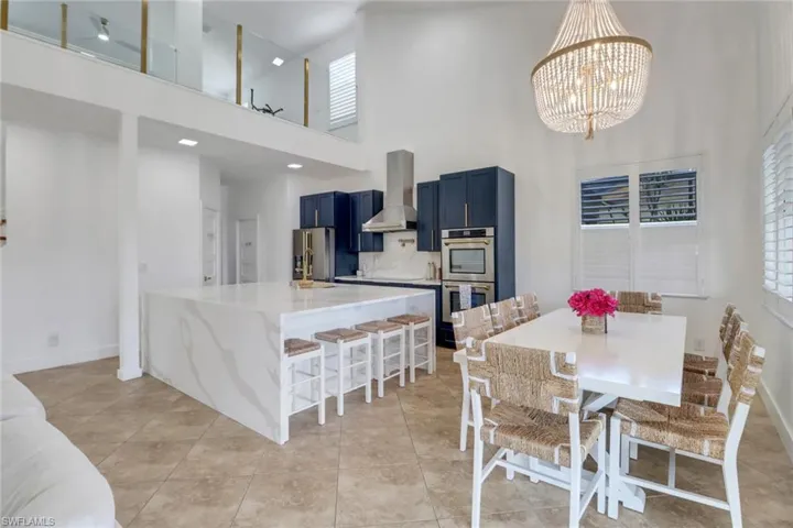 Dining area featuring baseboards, a high ceiling, a chandelier, and light tile patterned floors