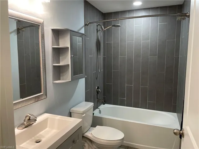 Full bathroom featuring toilet, vanity, and tiled shower / bath