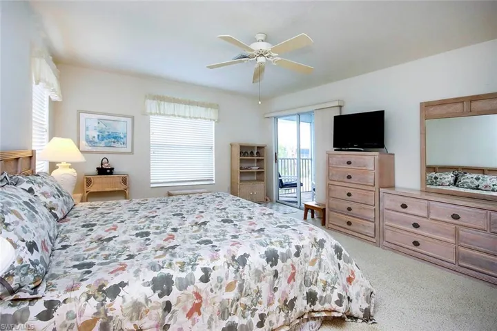 Carpeted bedroom with access to outside and a ceiling fan