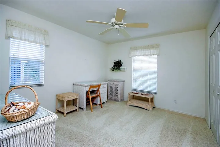 Sitting room featuring ceiling fan and carpet flooring