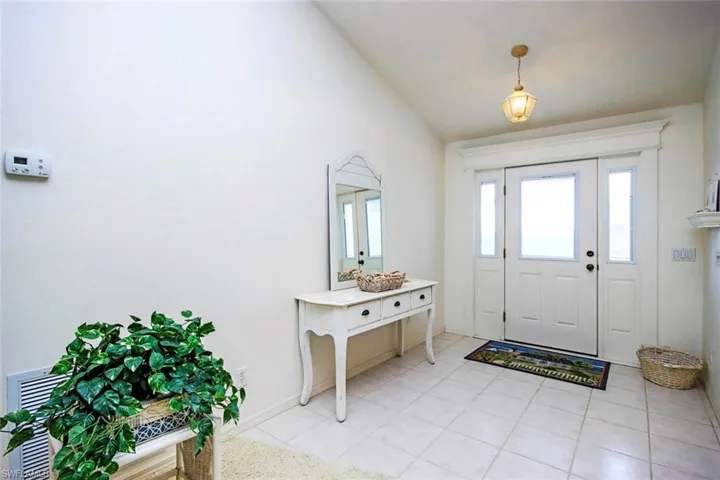 Entryway featuring baseboards and lofted ceiling