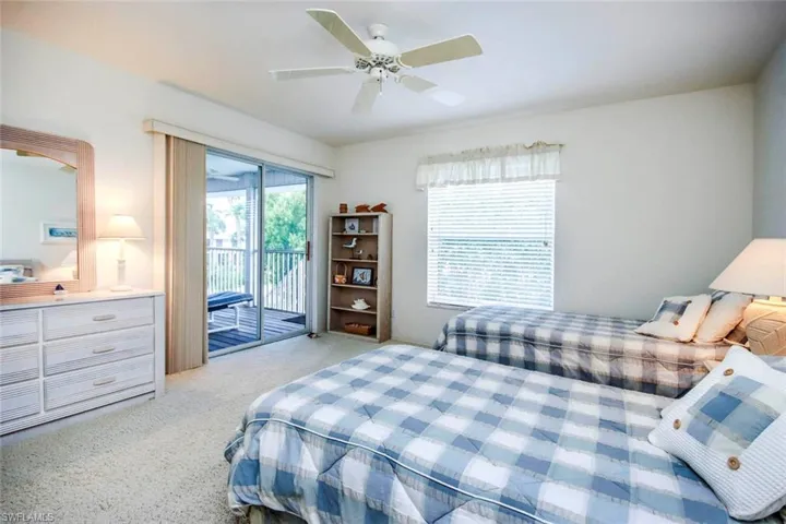 Bedroom with access to exterior, a ceiling fan, and light colored carpet
