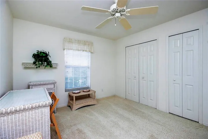 Carpeted bedroom featuring multiple closets, a ceiling fan, and baseboards