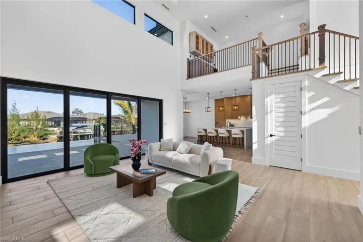 Living room featuring wood finished floors, recessed lighting, and a high ceiling