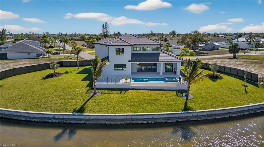 Back of property with a patio area, a residential view, a fenced backyard, a water view, and stucco siding