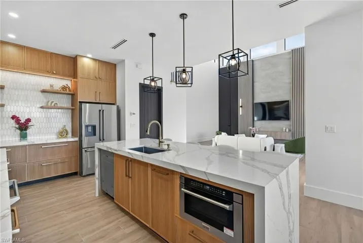 Dual tone kitchen featuring light stone counters, open shelves, modern cabinets, and dual tone cabinets