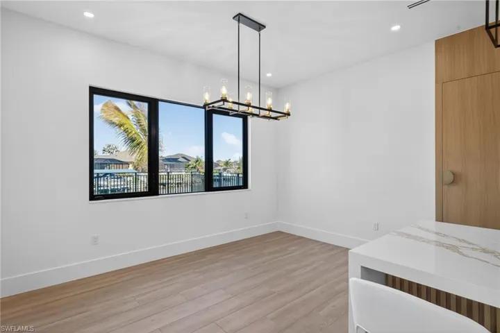 Unfurnished dining area featuring light wood finished floors and hanging lights