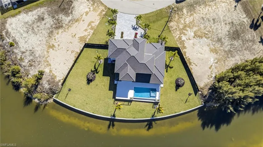 Aerial view of property and surrounding area with a nearby body of water