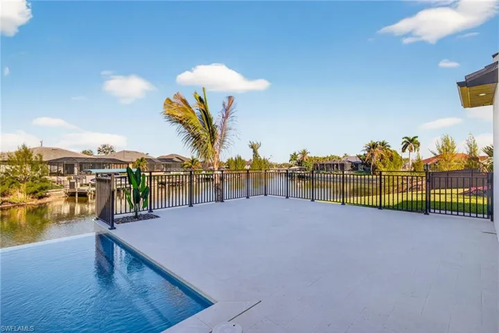 View of swimming pool with a water view, a residential view, and patio surround