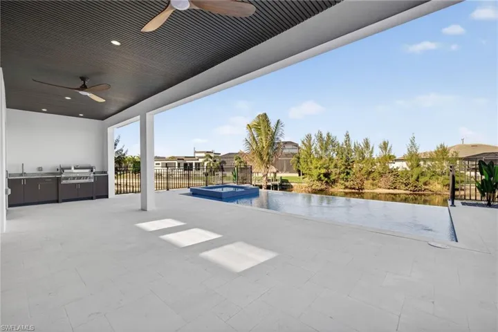 View of patio / terrace featuring ceiling fan, area for grilling, and a pool with connected hot tub