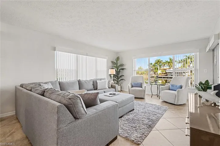 Living area with a textured ceiling and light tile patterned flooring