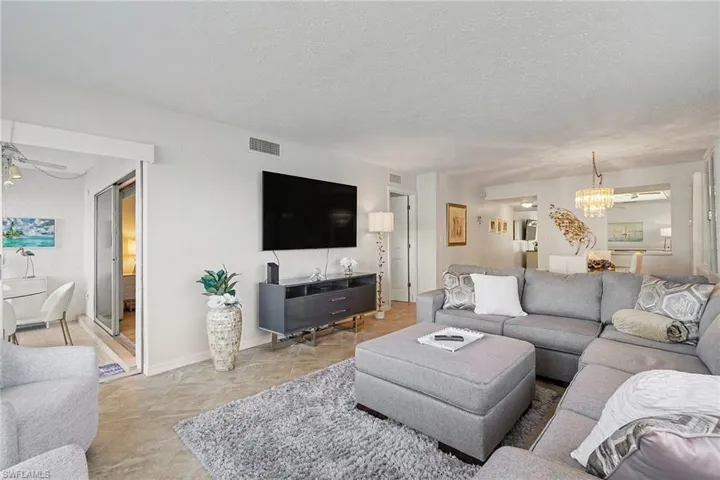 Living room featuring a textured ceiling, a chandelier, and a ceiling fan