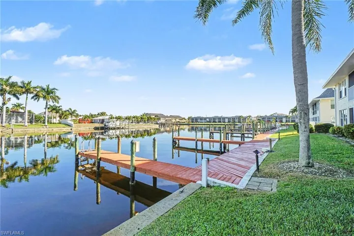 Dock area featuring a water view and a lawn