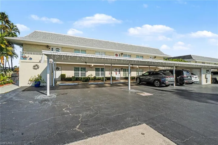 View of building exterior featuring covered parking