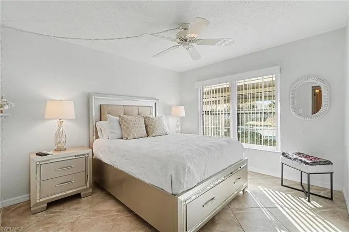 Bedroom with ceiling fan and a textured ceiling