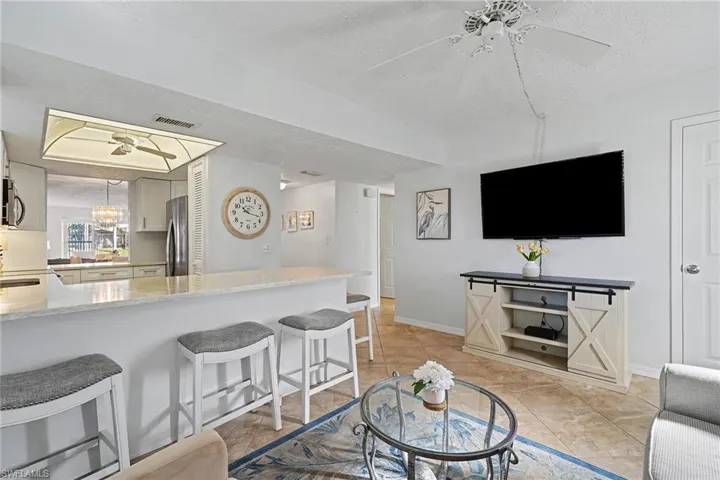 Living room with ceiling fan and a textured ceiling
