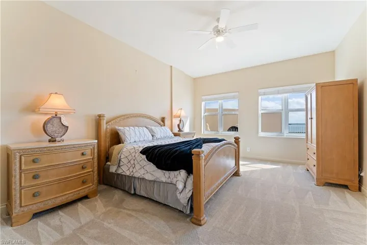 Bedroom with ceiling fan and light carpet