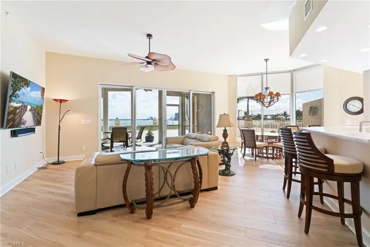 Living area featuring ceiling fan, light wood-style floors, and a chandelier