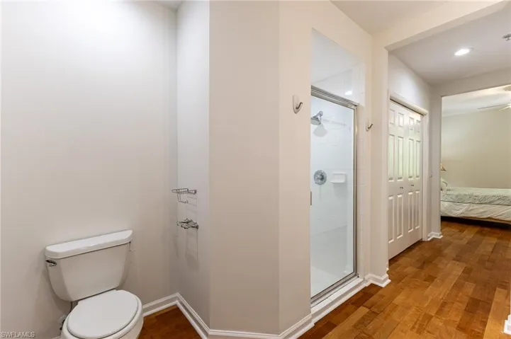 Ensuite bathroom with a stall shower and wood finished floors