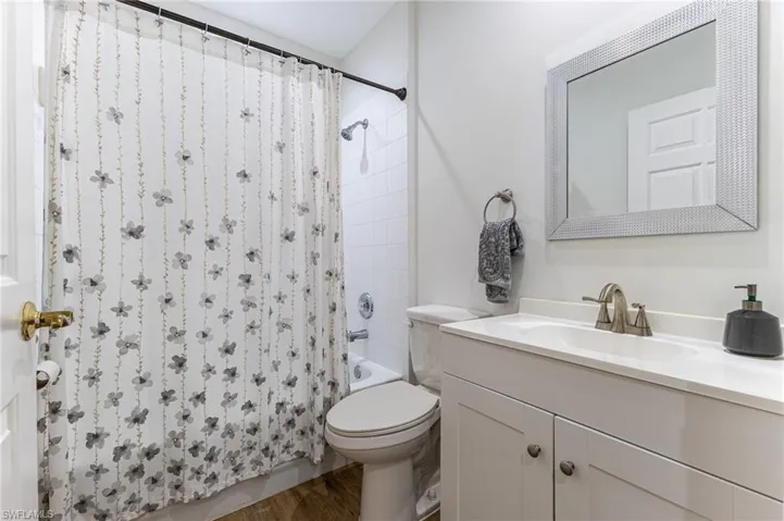 Full bathroom featuring vanity, wood finished floors, and shower / bath combo