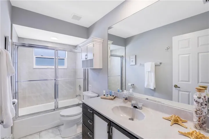 Full bath with vanity and combined bath / shower with glass door