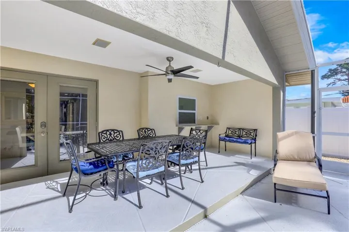 View of patio featuring outdoor dining space, french doors, a ceiling fan, and a sunroom