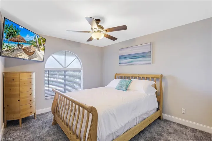 Bedroom with a ceiling fan and dark carpet