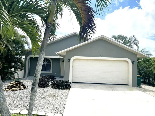 Single story home with an attached garage, stucco siding, and concrete driveway