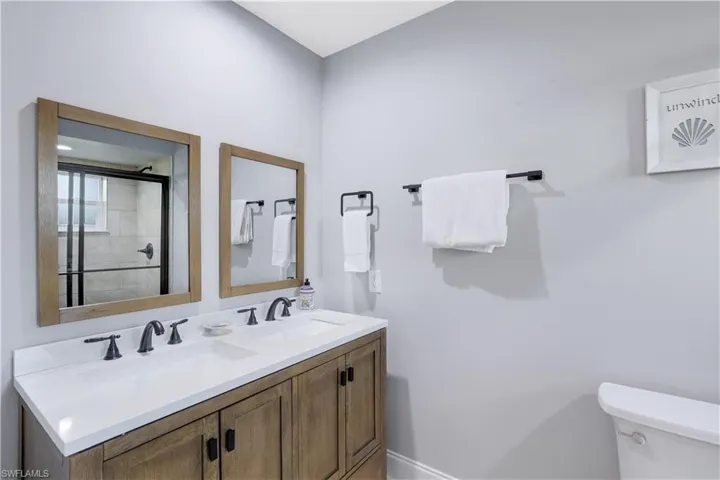 Bathroom featuring double vanity and an enclosed shower