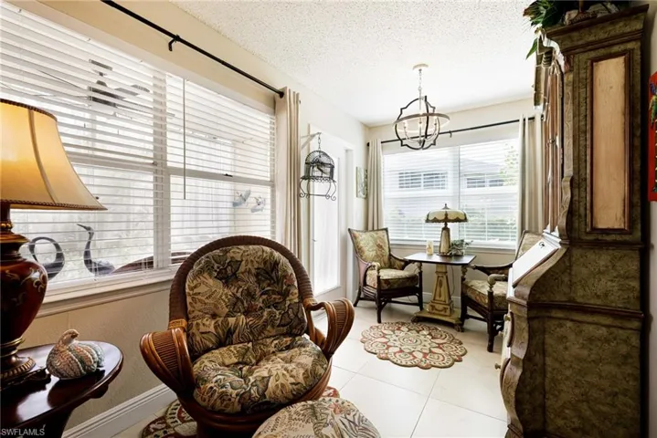 Sitting room with a chandelier, light tile patterned floors, and a textured ceiling