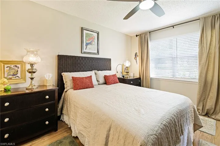 Bedroom with wood finished floors, a textured ceiling, and a ceiling fan