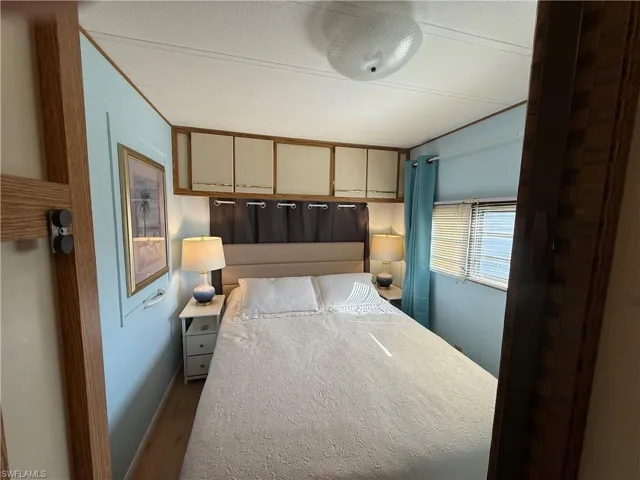 Bedroom with wood finished floors and baseboards