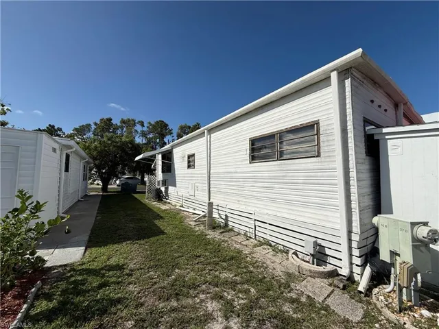 View of property exterior featuring a lawn