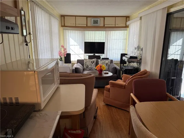 Living room with wood finished floors and healthy amount of natural light