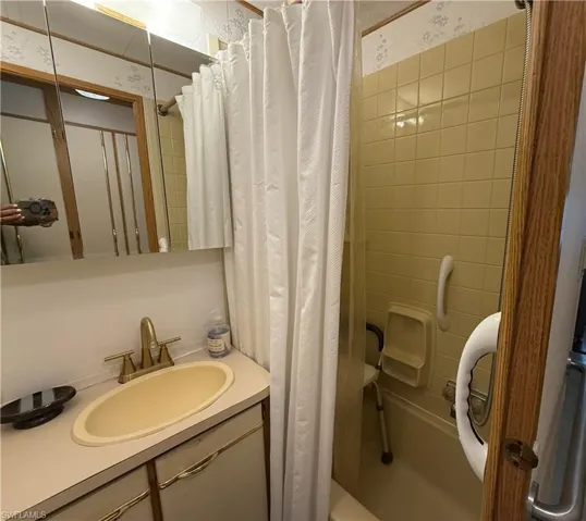 Full bathroom featuring shower / bathtub combination with curtain and vanity