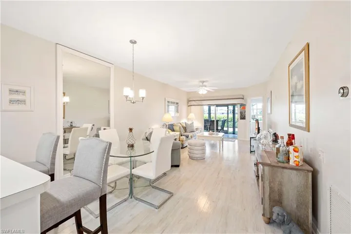 Dining room featuring light wood-type flooring, a chandelier, and a ceiling fan