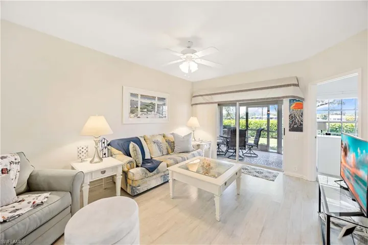 Living room featuring a ceiling fan, light wood-style floors, and baseboards
