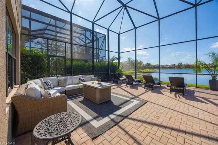 View of patio with an outdoor hangout area, a water view, and a lanai