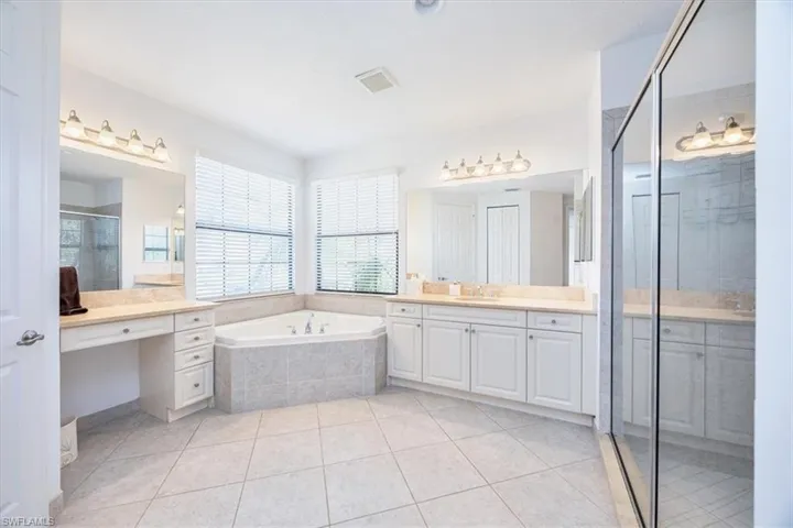 Bathroom featuring vanity, independent shower and bath, and tile patterned floors