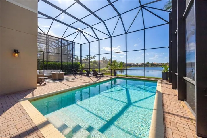 View of pool featuring a patio, a water view, and a lanai
