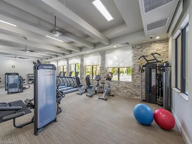 Exercise room featuring a ceiling fan, beam ceiling, and recessed lighting