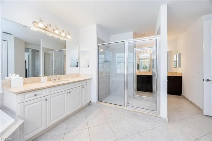 Bathroom with vanity, shower with separate bathtub, and tile patterned floors